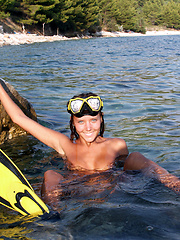 Adorable teen diver in flippers and swim mask showing off incredible nude body on the seaside.