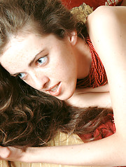 Perfect dark haired naked teen bombshell spreads legs revealing shaved cunt on the sofa