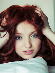 Enticing redhead with seductive, bedroom eyes and youthful allure.